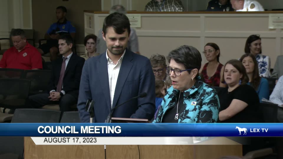 Mayor Linda Gorton reads the CivicLex Day proclamation while Richard Young stands at the podium beside her, surrounded by the CivicLex team
