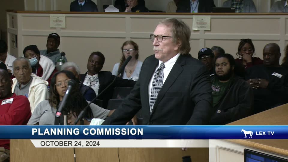 Simpson at the Planning Commission podium with elderly Pralltown residents seated in the front row beside him