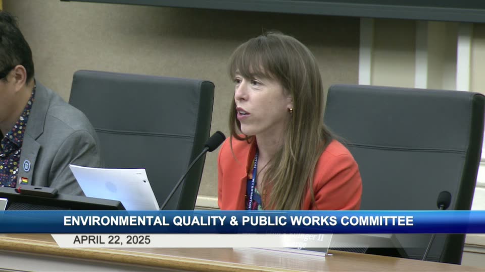 Council Member Hannah LeGris speaking at the dais in a red blouse, gesturing as she reads from a paper.