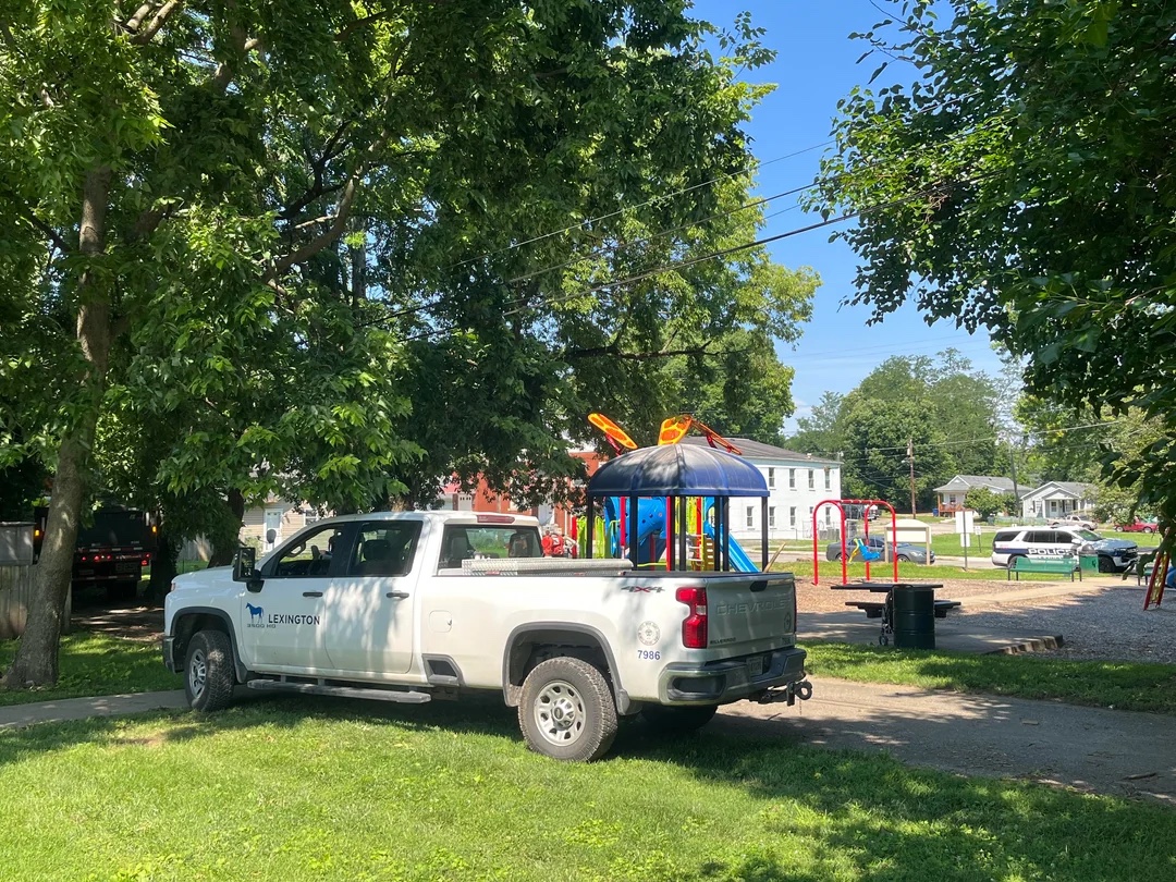 A white city pickup truck loaded with belongings, including a colorful child's play structure, at Brucetown Park