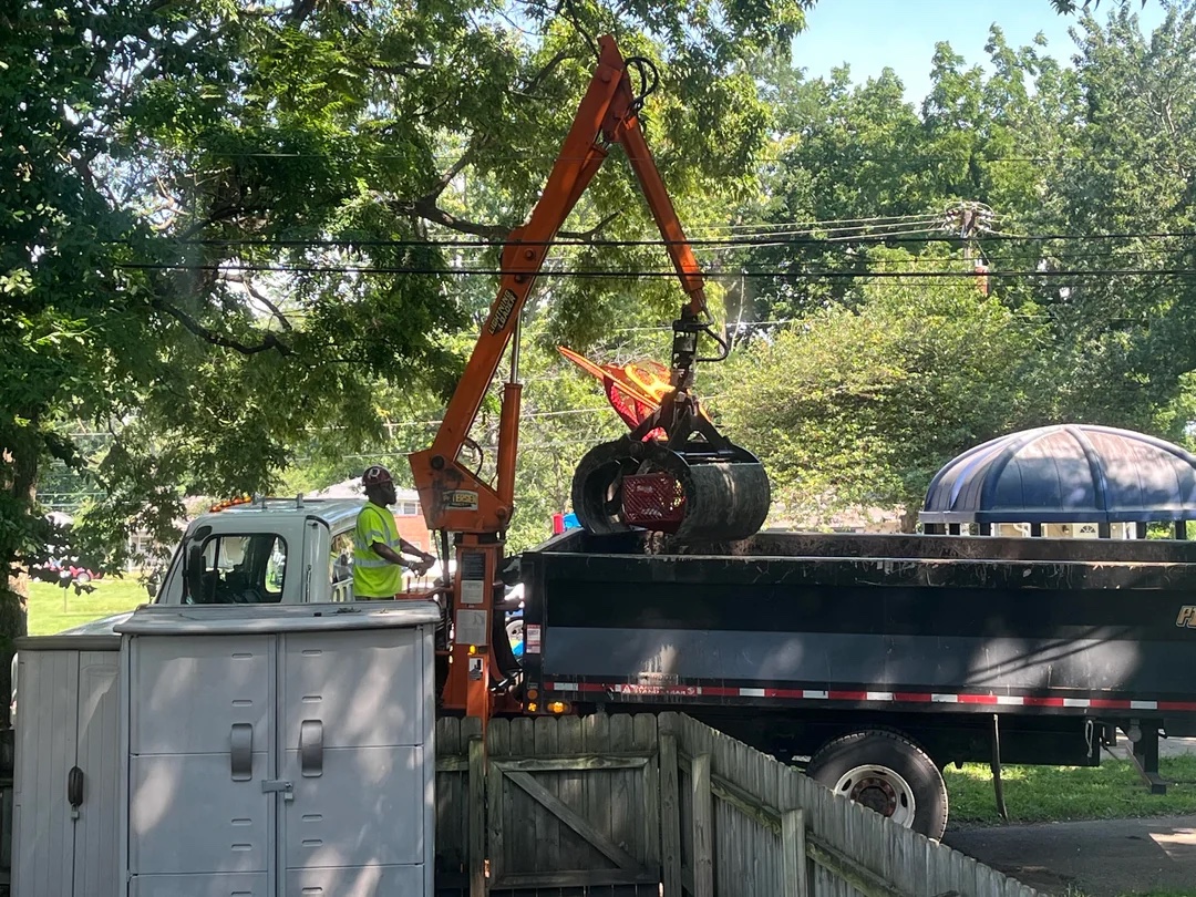 A city grapple truck lifts debris into a flatbed during the clearing of a homeless encampment at Brucetown Park in Lexington