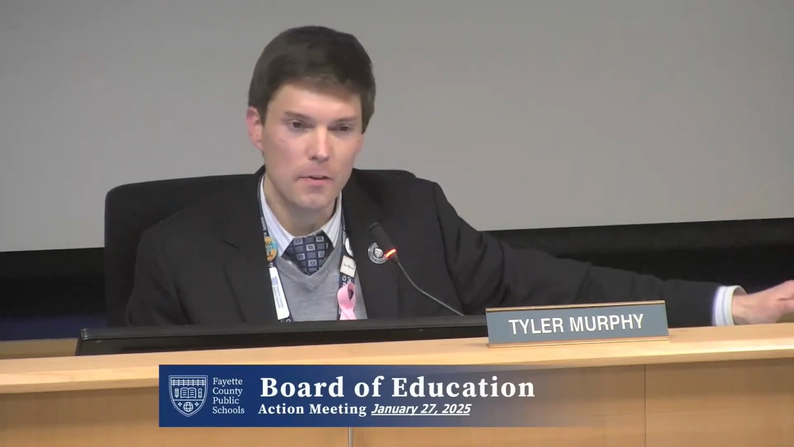 Tyler Murphy speaking at the dais with his nameplate visible