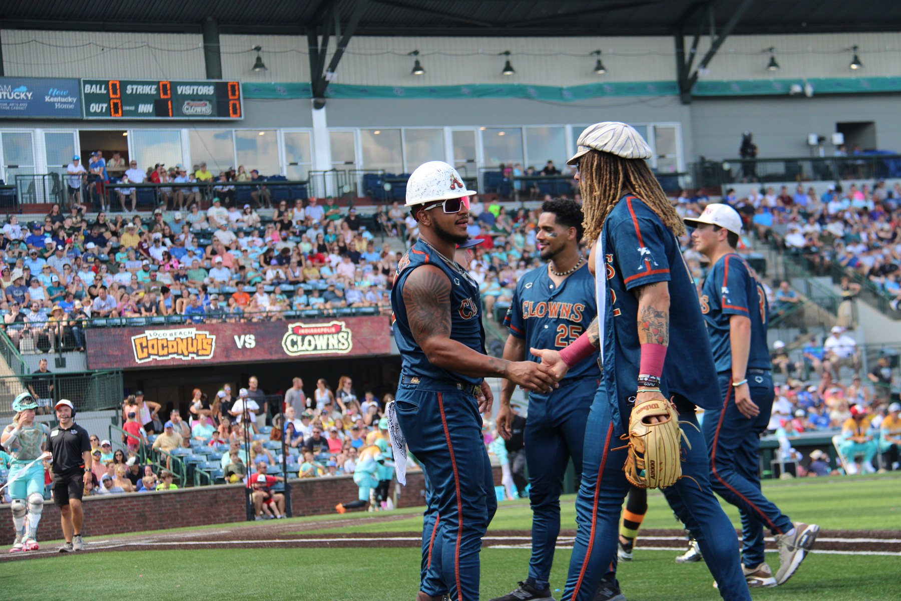 Clowns players greet each other on the infield before the game.