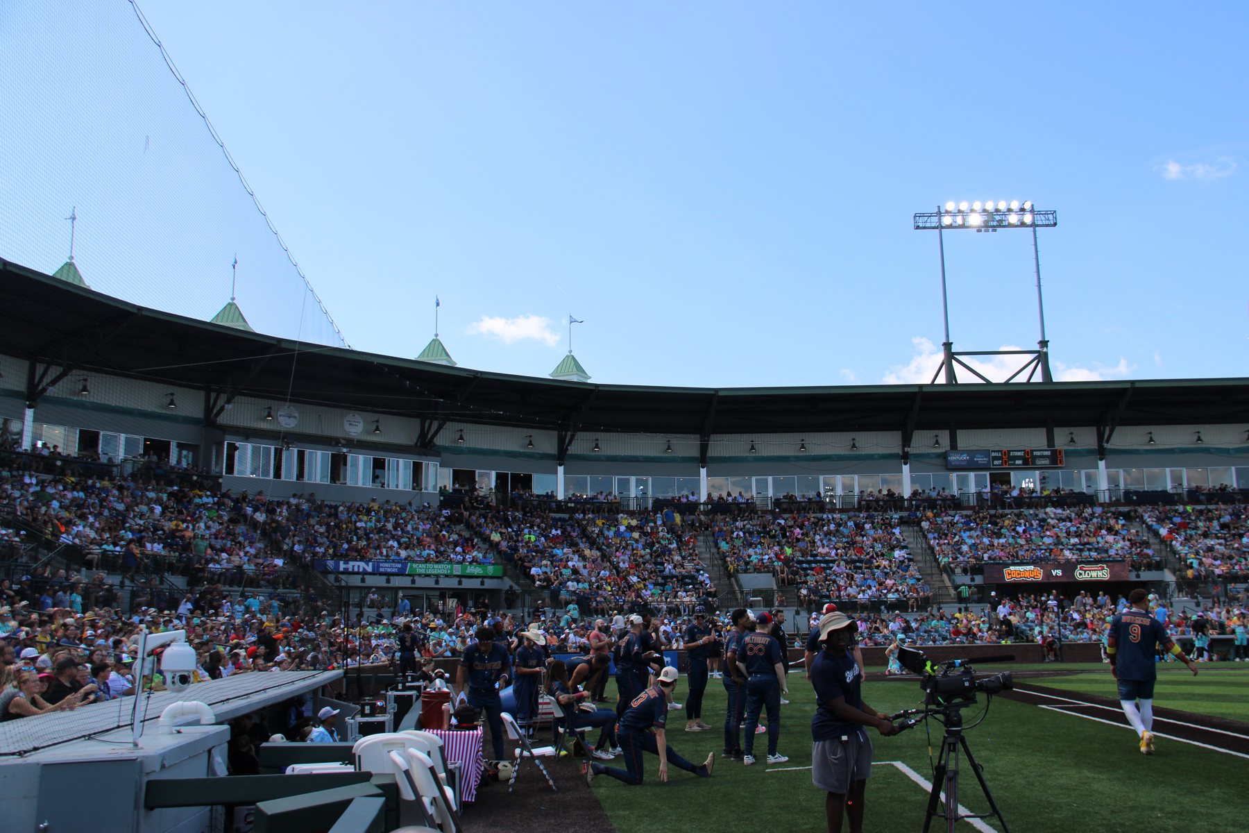 Indianapolis Clowns players warm up on the first-base side as the crowd settles in.