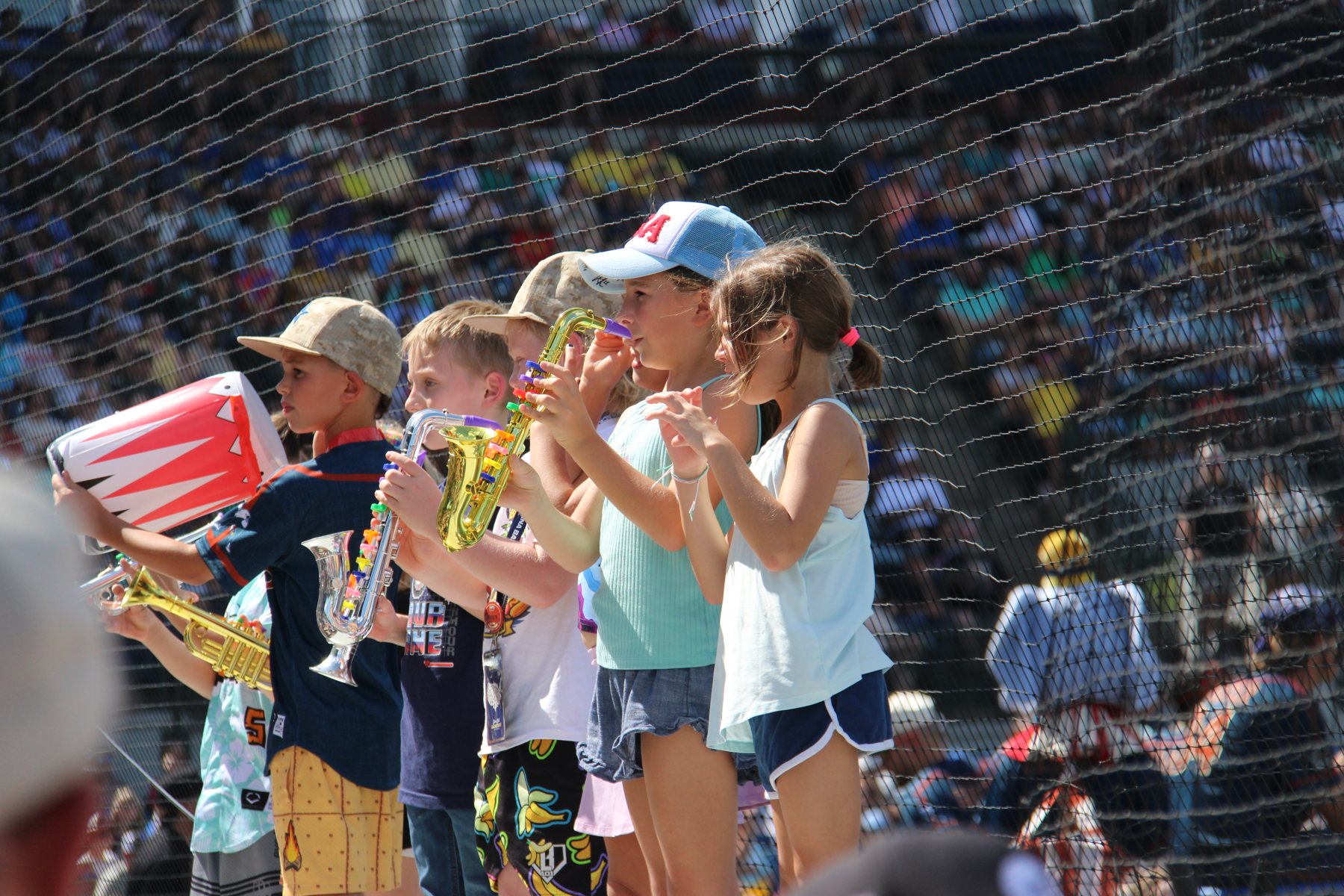 Kids in the front row play toy saxophones and trumpets along with the show.